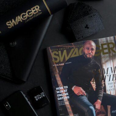 A dark and stylish flat lay featuring a magazine and tech items for a sleek look.